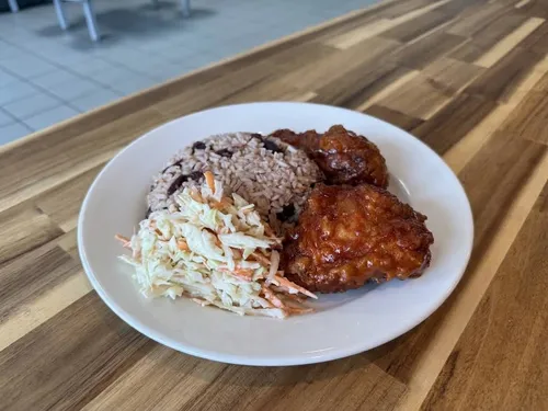 BBQ-glazed fried chicken served with rice and peas and coleslaw