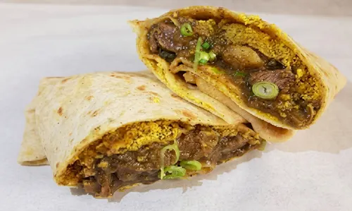 A curried beef roti wrap cut in half